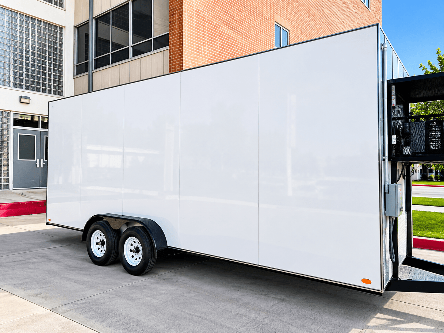 White mobile refrigeration trailer parked beside a building